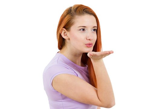 Young attractive woman blowing a kiss on white background 
