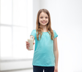 smiling little girl giving glass of milk