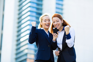 Fototapeta premium Happy businesswomen celebrating success, corporate office