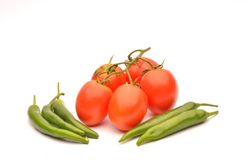 Tomatoes and hot chilli on background