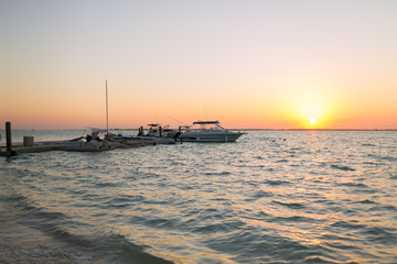 boats moored to pier at sundown
