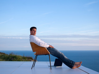 relaxed young man at home on balcony