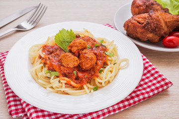 Spaghetti with meatballs in tomato sauce and deep fried chicken