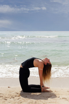 Stock image of ustrasana yoga pose on the beach