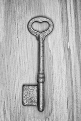 old key with heart shape ring hole on wood texture background