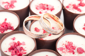 Obraz na płótnie Canvas Two wedding rings on chocolates with raspberries