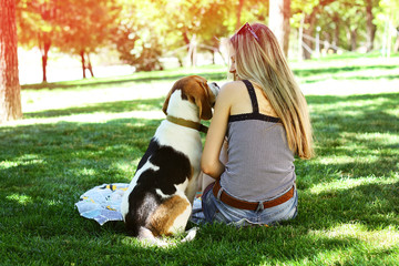 Happy young woman sit with dog and looking at dog nose