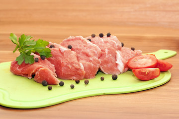 piece of raw meat with spices and vegetables