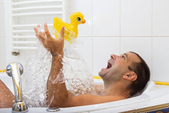 Man Playing In The Bath With Duck