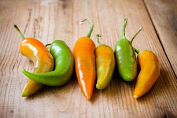 Raw pods hot peppers on a wooden background