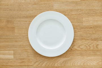 Empty white plate on wooden table
