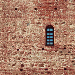 small arched window in a red brick