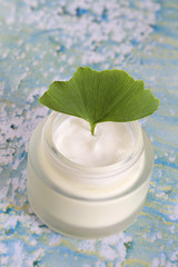 pot de crème hydratante avec feuilles fraîches de Ginkgo