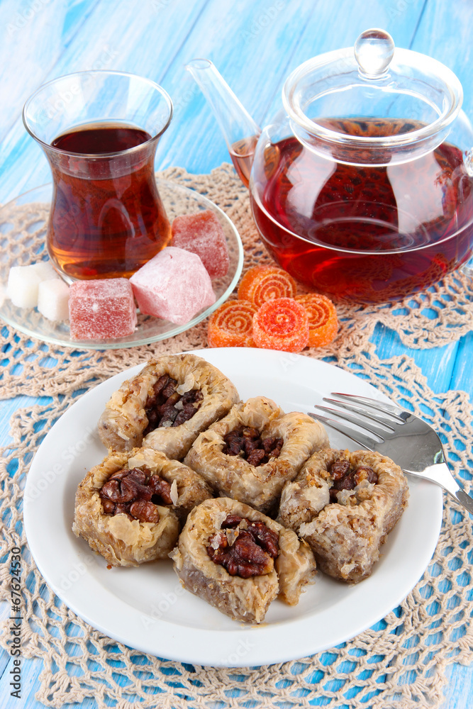 Wall mural Sweet baklava on plate with tea on table - Wall murals
