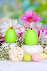 Obraz na płótnie Canvas Easter candles with flowers on bright background