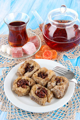 Sweet baklava on plate with tea on table