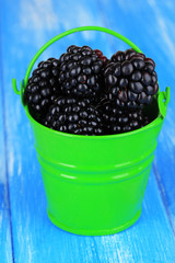 Sweet blackberries in bucket on table close-up