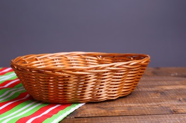 Obraz premium Empty wicker basket on wooden table, on dark background