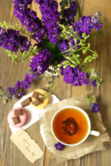 Cup of fresh herbal tea on wooden table