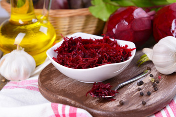 Grated beetroots in bowl on table close-up
