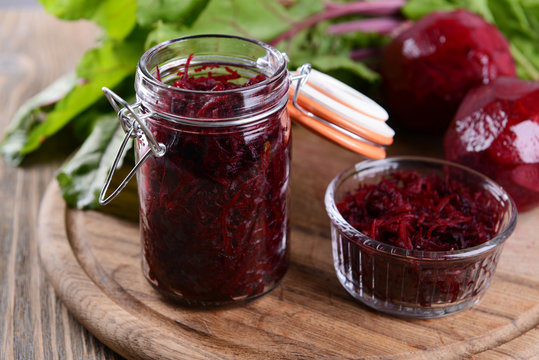 Grated beetroots in jar on table close-up
