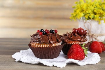 Tasty cupcakes on wooden background