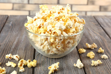 Popcorn in bowl on wooden table, close up