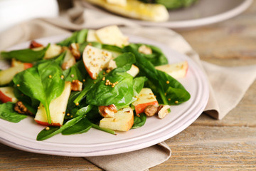 Green salad with apples, walnuts and cheese on wooden