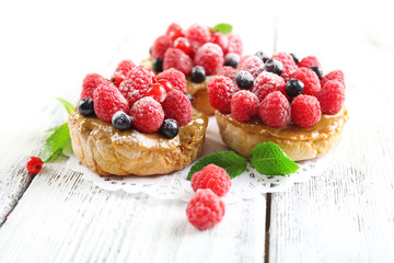 Sweet cakes with berries on table close-up