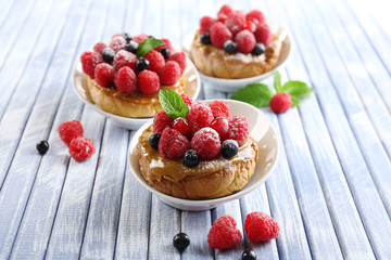 Sweet cakes with berries on table close-up