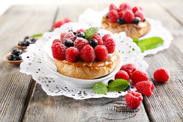 Sweet cakes with berries on table close-up