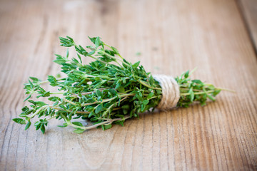 bunch of fresh thyme on a wooden background