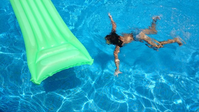 Ni&ntilde;a buceando junto al colchoneta verde