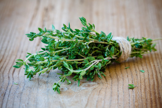 bunch of fresh thyme on a wooden background