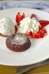 close up chocolate cake and cream in white dish