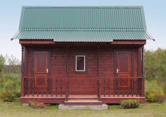 Small wooden house under green metal roof