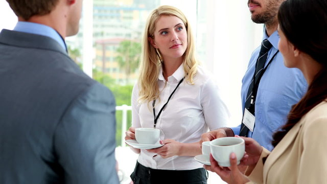 Business people standing at conference drinking coffee