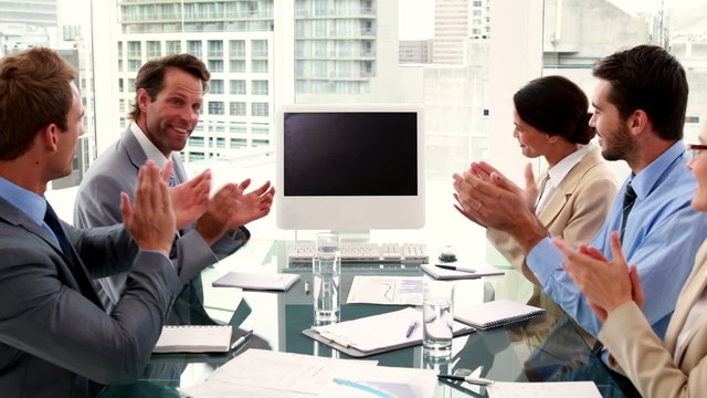 Business team clapping a blank screen