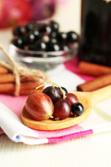 Ripe blackcurrants in bowl and glass jar with tasty jam