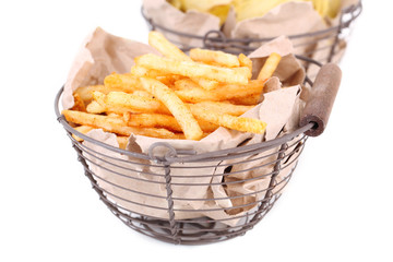 Tasty french fries in metal basket and potato chips, isolated