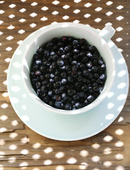 Useful blueberry in bowl on table, close-up
