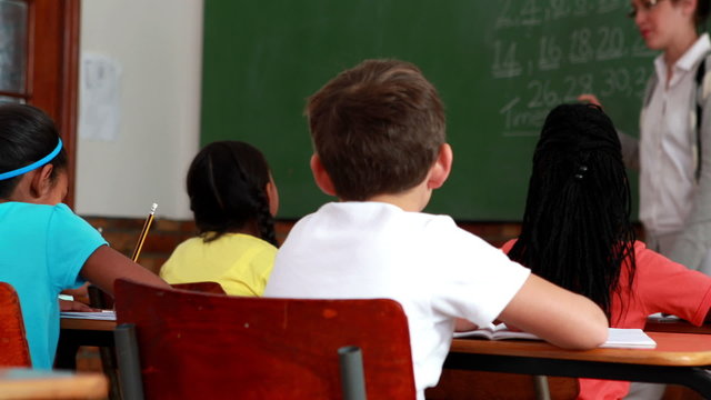 Pupils listening to their teacher at chalkboard