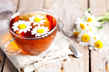 Fototapeta na wymiar cup of tea with chamomile flowers