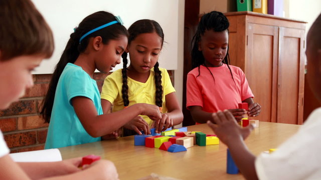 Pupils playing with building blocks in classroom