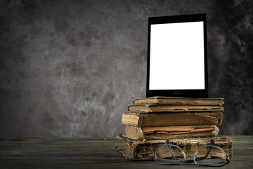 Old books with self-designed tablet computer and reading glasses