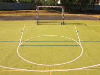 Empty outdoor hanball playground, plastic green surface, bounds