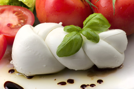 Mozzarella tomatoes and fresh salad on the white