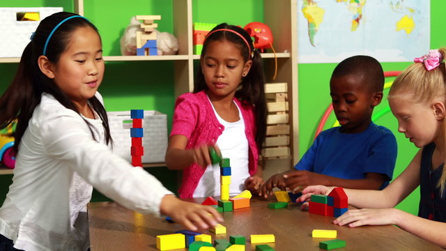 Cute classmates playing with building blocks