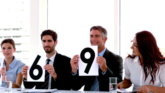 Business people on interview panel showing scores