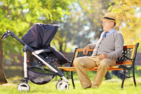 Grandfather sitting and looking at his baby nephew in a stroller